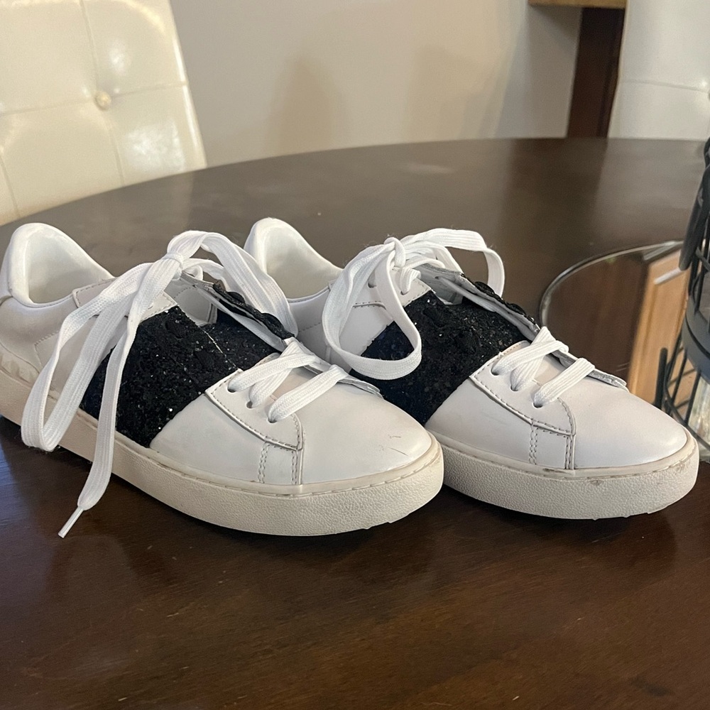Valentino white sneakers with black glitter/sequin accents.